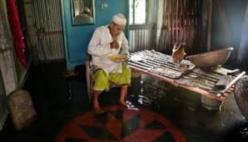 A man takes meal in an inundated house at North Baherchar of Keraniganj near the capital on Saturday while the flood situation witnessed a gradual improvement in different parts of the country. — Sony Ramany