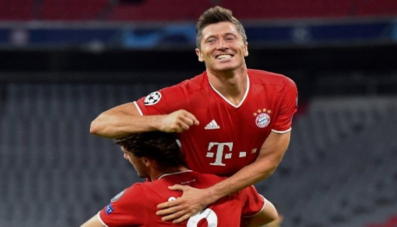 Bayern Munich forward Robert Lewandowski (up) celebrates with team-mate Alvaro Odriozola after scoring his team's fourth goal against Chelsea during their UEFA Champions League second-leg round of 16 match at the Allianz Arena on Saturday. — AFP photo