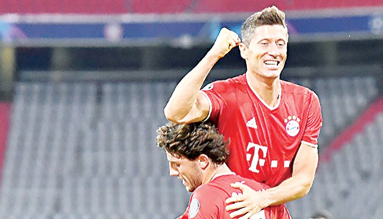 Bayern Munich forward Robert Lewandowski (up) celebrates with team-mate Alvaro Odriozola after scoring his team’s fourth goal against Chelsea during their UEFA Champions League round of 16 second-leg match in Munich on Saturday. — AFP photo