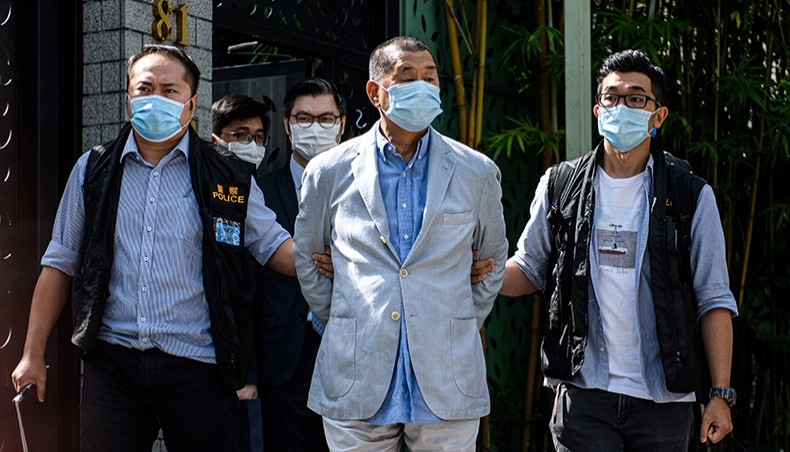 Police lead Hong Kong pro-democracy media mogul Jimmy Lai (C), 72, away from his home after he was arrested under the new national security law in Hong kong on Monday. — AFP photo