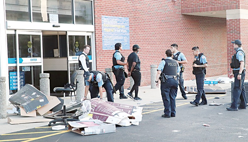 Police officers detain a man who was found inside of a Best Buy store after parts of the city had widespread looting and vandalism, on Monday in Chicago, Illinois. Police made several arrests during the night of unrest and recovered at least one firearm. — AFP photo