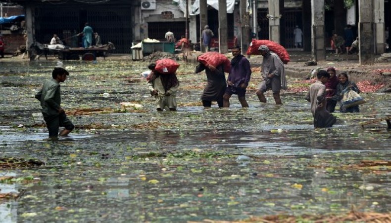 Labourers wade through a flooded fruit and vegetable market after heavy monsoon rains in Lahore on August 10, 2020.- AFP photo