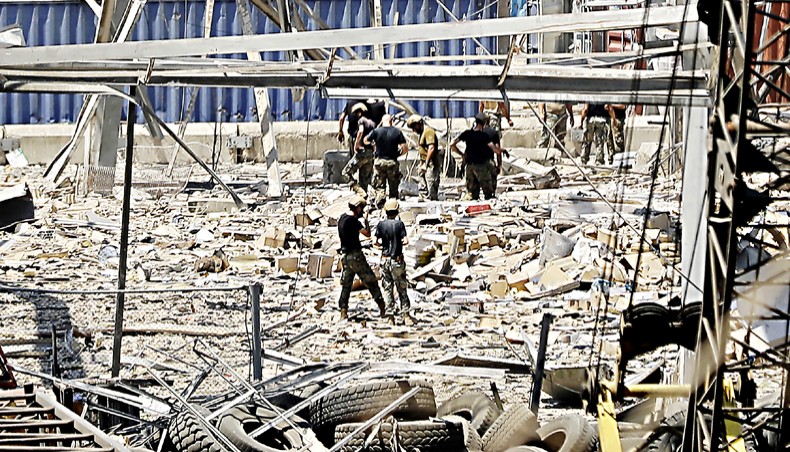 Rescuers and civil defence search through the debris at Beirut port’s silo on August 5 in the aftermath of a massive explosion in the Lebanese capital.— Agence France-Presse/Joseph Eid