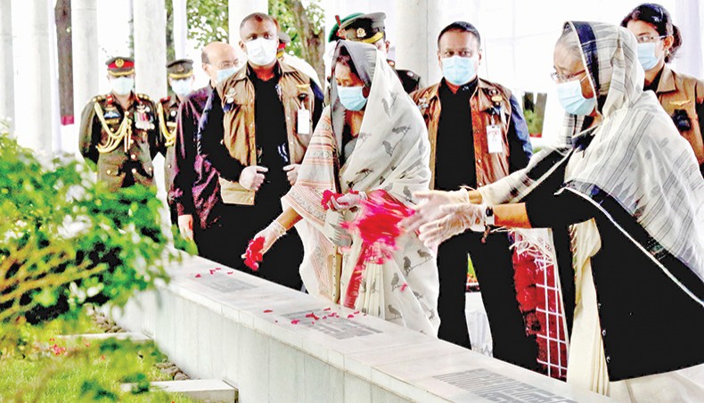 Prime minister Sheikh Hasina, along with her daughter Saima Wazed Hossain, on Saturday sprinkle petals on the graves of her family members who were killed on August 15, 1975. — Focusbangla photo