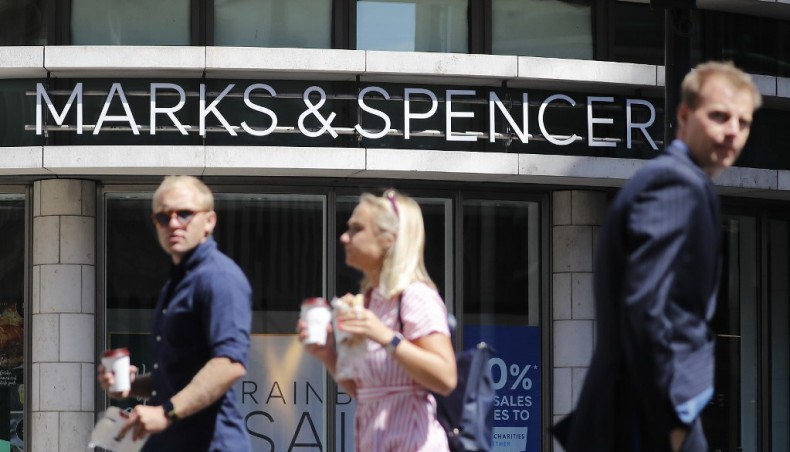 This file photo taken on July 20, 2020 shows pedestrians walk past an M&S (Marks and Spencer) store in central London. — AFP photo