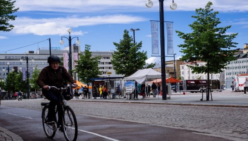 A cyclist rides past banners hanging from street lights promoting the city being the European green capital for the 2021 year in Lahti, where a pilot project is implemented to quantify the personal carbon footprint, on August 24, 2020.