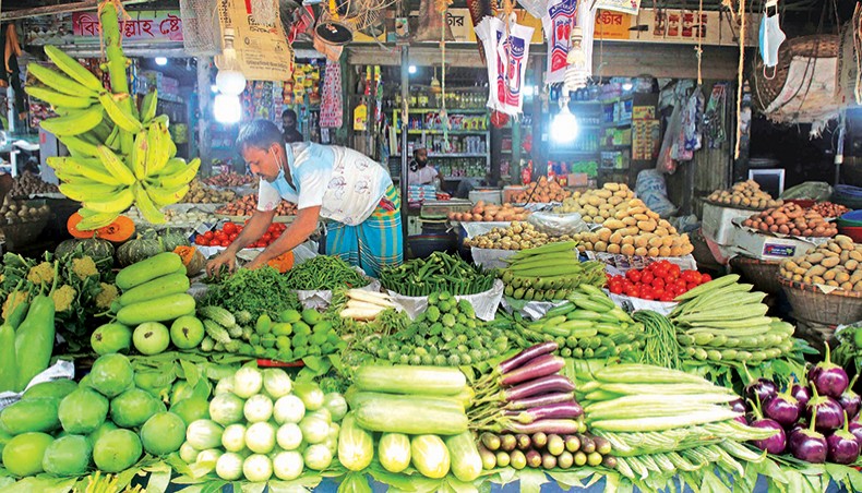 A file photo shows a vendor arranging vegetables at a shop at a kitchen market in the capital. The prices of vegetables and ginger went up on the kitchen markets in the capital over the week ending Friday. — New Age photo