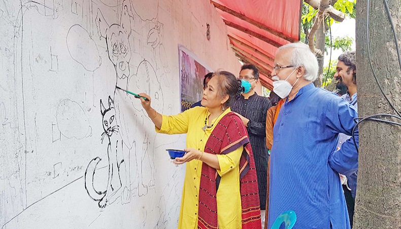Artist Kanak Chapa Chakma draws street animals on a wall as artist Abul Barq Alvi looks on during the inauguration of an awareness programme through graffiti on Road 10A of Dhanmondi in Dhaka on Friday organised by People for Animal Welfare Foundation and supported by Globe Pharma Group of Companies. — Sourav Lasker