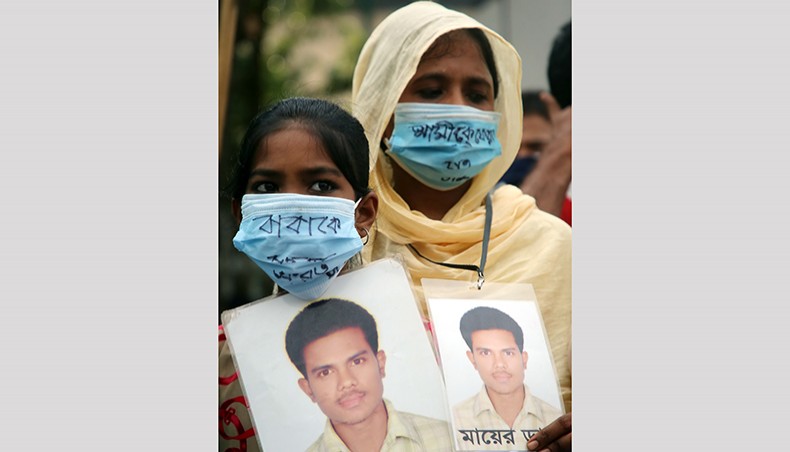 A woman, along with her daughter, holds the picture of her missing husband at a rally organised by voluntary organisation Mayer Daak at Shahbagh on Saturday, marking International Day of the Victims of Enforced Disappearances. — Sony Ramany