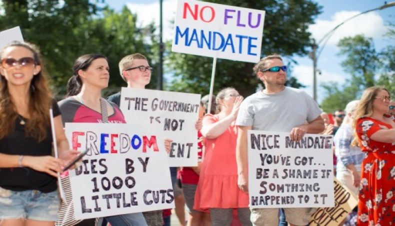 Anti-vaccine activists hold signs in front of the Massachusetts State House during a protest against Governor Charlie Baker's mandate that all Massachusetts school students enrolled in child care, pre-school, K-12, and post-secondary institutions must receive the flu vaccine this year on August 30, 2020 in Boston,- AFP photo