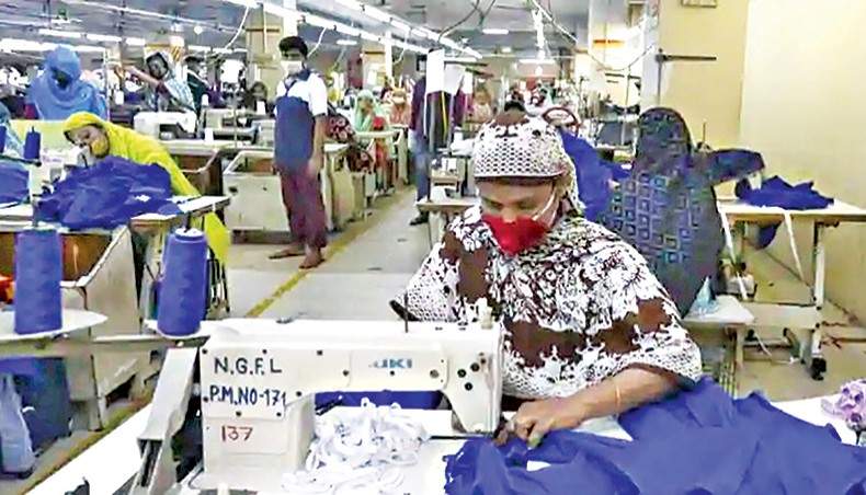 A file photo shows workers wearing facemasks sewing clothes in a garment factory in Dhaka in May. The country’s readymade garment export growth turned positive in August this year with a robust 44.63 per cent year-on-year growth after seven months of negative trend. — AFP photo