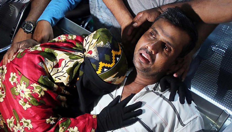A shellshock man goes blank while his wife wails after losing their two sons in the gas explosion at Narayanganj mosque on Friday night. The photo was clicked at the Sheikh Hasina National Institute of Burn and Plastic Surgery in Dhaka on Saturday. — Sony Ramany