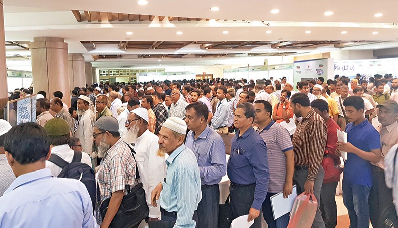 A file photo shows a large number of people waiting in queues to file tax returns on the opening day of the Income Tax Fair 2019 at Officers’ Club Dhaka. The National Board of Revenue has taken a move to finalise the draft of the new Income Tax Act-2020 by this month to expedite introduction of the new law following pressure from government high-ups, officials said. — New Age photo