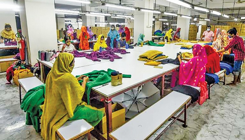 A file photo shows labourers wearing facemasks working in a garment factory as a preventive measure against the spread of the COVID-19 coronavirus in Dhaka recently. The coronavirus outbreak has affected the livelihoods of 82 per cent of readymade garment workers in Bangladesh and more than half of the affected workers had been forced to spend savings and borrow money to cover their expenses, according to a survey released on Monday. — AFP photo