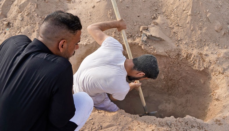 An Iraqi family digs up the corpse of a relative, who died of the novel coronavirus, at a coronavirus cemetery in a plot of desert outside the Shiite holy city of Najaf to be transferred to a family cemetery for reburial on September 11, 2020. — AFP photo