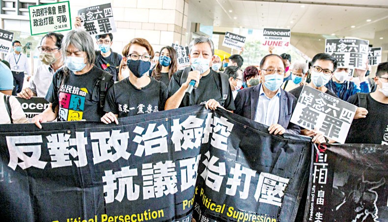Pro-democracy activist Lee Cheuk-yan, centre, Figo Chan, centre left, and Leung Kwok-hung, left, known as ‘Long Hair’, facing charges related to commemorations of the 1989 Tiananmen Square crackdown in Beijing earlier this June 4, arrive at the West Kowloon court in Hong Kong on Tuesday.— AFP photo