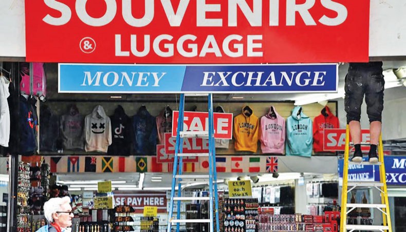 A file photo shows a man standing on a ladder inside a souvenir shop on Oxford Street in central London on June 11, 2020, as non-essential shops prepare to re-open on June 15. Britain’s unemployment rate jumped above four per cent in July on economic fallout from the coronavirus pandemic, official data showed on Tuesday. — AFP photo