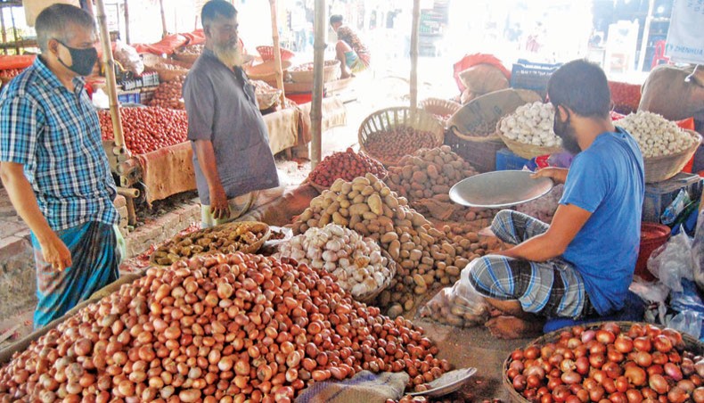 A vendor sells different commodities including onions at a kitchen market at Matuail in the capital on Friday. The prices of onion, ginger and garlic went up on the city’s kitchen markets over the week ending Friday.— Focusbangla photo