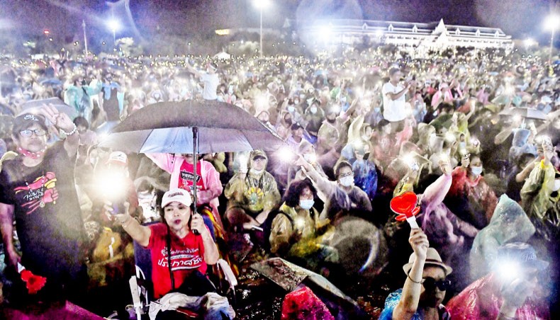 Anti-government protesters hold aloft their mobile phones as they take part in a pro-democracy rally in Bangkok on Saturday. — AFP photo