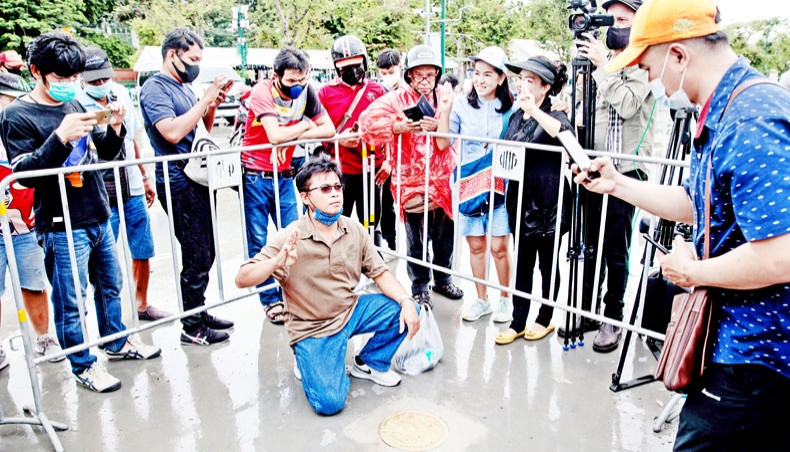 People take photos with a commemorative plaque placed by pro-democracy protest leaders on the Sanam Luang pitch in Bangkok on Sunday, after an overnight anti-government demonstration. — AFP photo