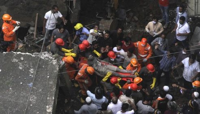 Rescue workers carry a survivor from the rubble of a collapsed three-storey residential building in Bhiwandi on September 21, 2020. — AFP photo