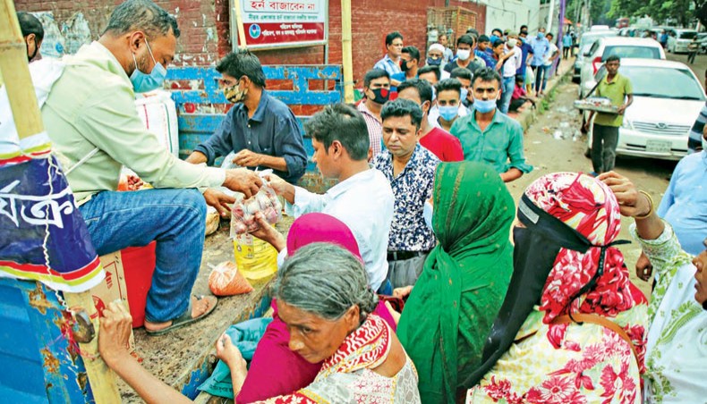 A salesperson hands over onions to a customer standing in queue at a Trading Corporation of Bangladesh-run open market sales point near the Bangladesh Secretariat building in the capital on Tuesday. State-owned TCB on September 13 started selling four essential commodities, including onion, at subsidised rates across the country to contain the price spiral of daily essentials. — Sony Ramany