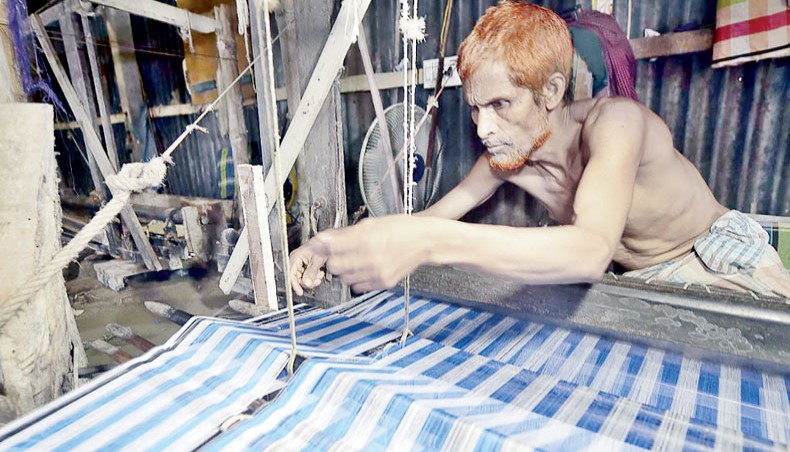 In this picture taken on September 15, 2020, a weaver uses a handloom to make fabric in Ruhitpur on the outskirts of Dhaka.— AFP photo