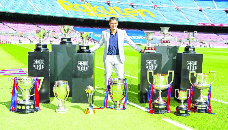 Barcelona forward Luis Suarez poses with the trophies before leaving the Catalan club to join Atletico Madrid at the Camp Nou on Thursday. -- Twitter photo