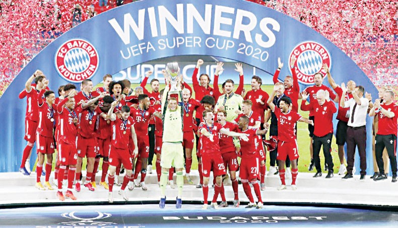 Bayern Munich players celebrate with the trophy after defeating Sevilla in the UEFA Super Cup at the Puskas Arena in Budapest on Thursday. — AFP photo