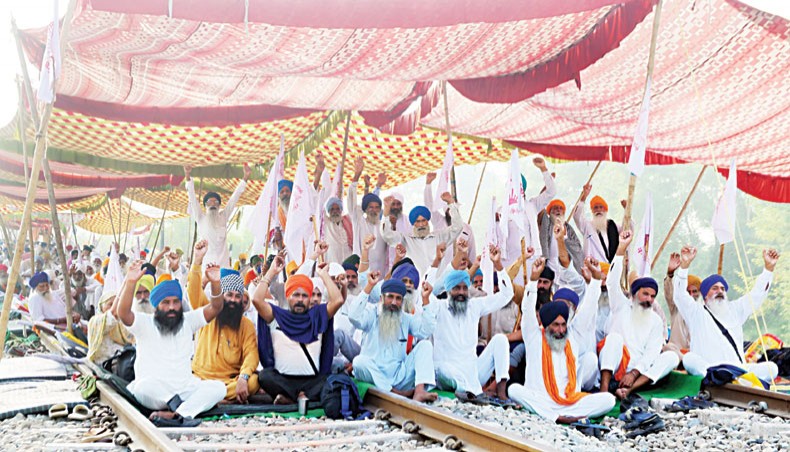 Farmers shout slogans and block train tracks during a nationwide farmers’ strike following the recent passing of agriculture bills in the Lok Sabha (lower house), at Devi Dasspura village some 25 kms from Amritsar on Friday. — AFP photo