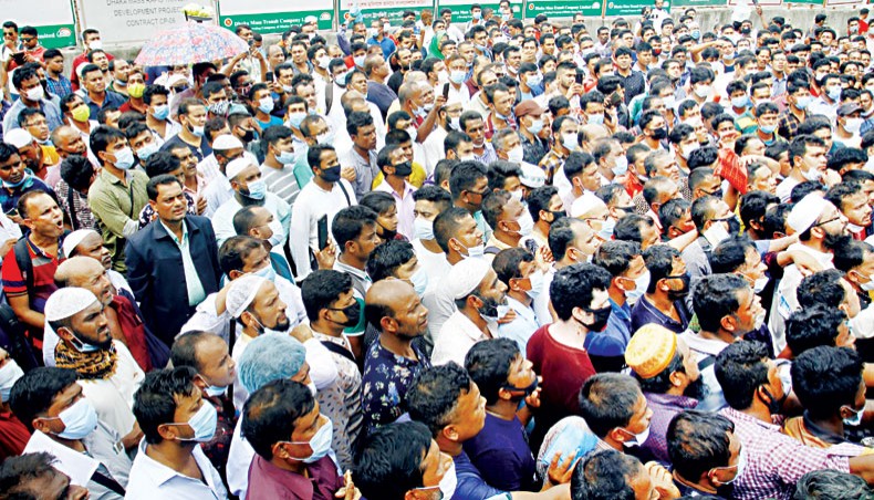 Migrant workers gather on the road in front of the Saudia Airlines office at Karwan Bazar in Dhaka on Saturday for air tickets to Saudi Arabia. — New Age photo