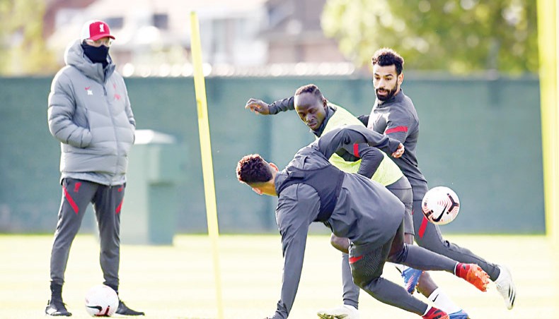 Liverpool forward trio Roberto Firmino, Sadio Mane and Mohamed Salah fight for the ball as manager Jurgen Klopp (L) looks on during a training session on Saturday. — Twitter photo