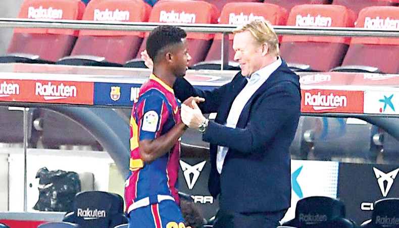 Barcelona coach Ronald Koeman (R) greets forward Ansu Fati during their La Liga match against Villarreal at the Camp Nou stadium on Sunday.— AFP photo
