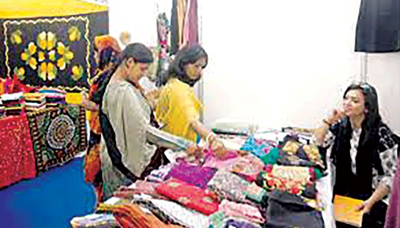 A file photo shows visitors browsing products at a stall at an SME fair held in Dhaka. Experts and businesses on Wednesday recommended that the government adopt an alternative stimulus package disbursement process for cottage, micro and small enterprises to speed up the disbursement of stimulus loans and make the package effective.— New Age photo