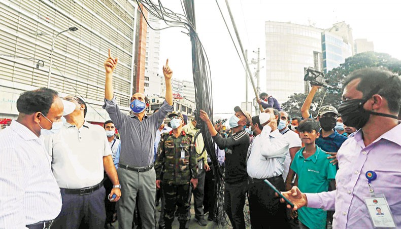 Dhaka north city mayor Atiqul Islam inspects the overhead cable removing operations at Gulshan-2 in Dhaka on Thursday. — New Age photo