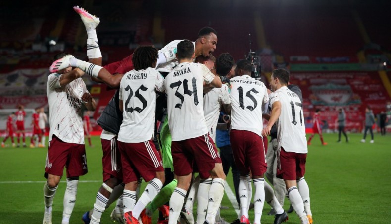 Arsenal players celebrate after defeating Liverpool in English League Cup fourth round match at Anfield on Thursday. — AFP photo