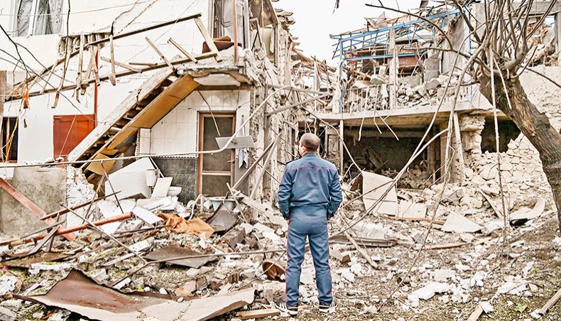 A police officer stands in front of a destroyed house after shelling in the breakaway Nagorno-Karabakh region’s main city of Stepanakert on Wednesday, during the ongoing fighting between Armenia and Azerbaijan over the disputed region. — AFP photo