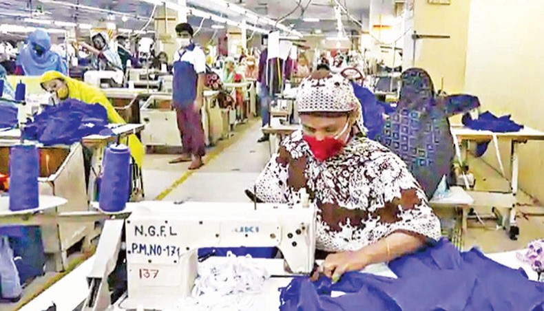 A file photo shows workers wearing facemasks sewing clothes in a garment factory in Dhaka in May. Bangladesh’s readymade garment exports to the United States in January-August this calendar year fell by 14.56 per cent or $594 million compared with that in the same period of 2019 as consumption still remained slow in the destination due to the impact of coronavirus pandemic. — AFP photo