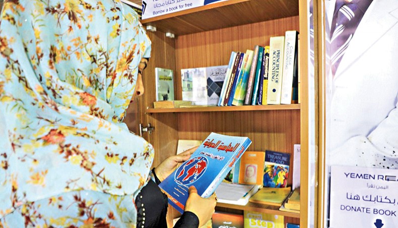 A Yemeni woman checks out a book from a mini-library, put in place by “Yemen Reads” campaign, in the capital Sanaa on September 29, 2020. — AFP photo