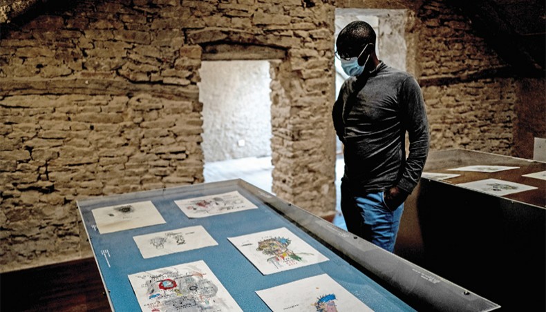 A gallery manager examines the exhibition of Basquiat drawings, at the Volcano gallery in Nuits-Saint-Georges on October 7, 2020. — AFP photo