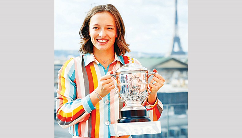 Poland’s Iga Swiatek poses with the trophy near the Eiffel Tower in Paris Sunday a day after winning French Open 2020 women’s singles title. — AFP photo