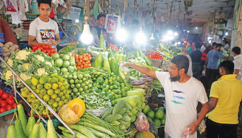 A man buys vegetables from a vendor at the Segunbagicha kitchen market in the capital on Friday. — New Age photo
