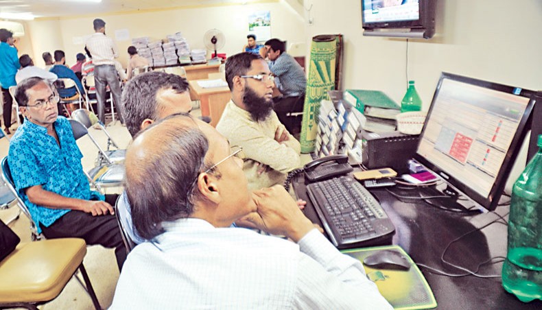 A file photo shows people monitoring share price movements on a computer screen at a brokerage house in the capital. Dhaka stocks in the past week fell for the second consecutive week as investors continued to sell-off shares to avoid losses amid a market slowdown in recent weeks while a number of large capitalised companies surged on expectation of better financial results. — New Age photo