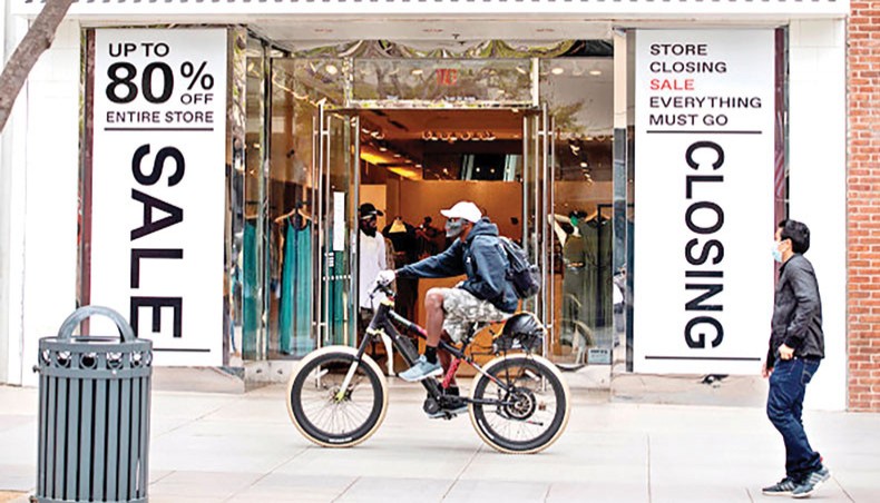 A file photo shows people wearing a mask pass by a store closing soon in Santa Monica, California, on July 28, 2020, amid the coronavirus outbreak. The US budget deficit surged 218 per cent to a record $3.1 trillion in the fiscal year ended September 30 due to a massive increase in spending to help the economy weather the coronavirus outbreak, the government announced on Friday. — AFP photo