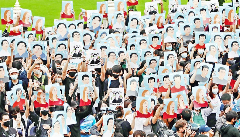 Pro-democracy protesters hold up posters of various activists during an anti-government rally at Victory Monument in Bangkok on Sunday, as they continue for the fourth consecutive day to defy an emergency decree banning gatherings. — AFP photo