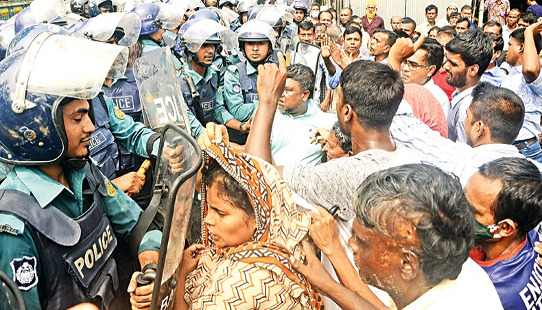 Police and agitating jute mill workers clash on Khulna-Jashore highway at Eastern Jute Mill gate point in Khulna on Monday morning. — New Age photo