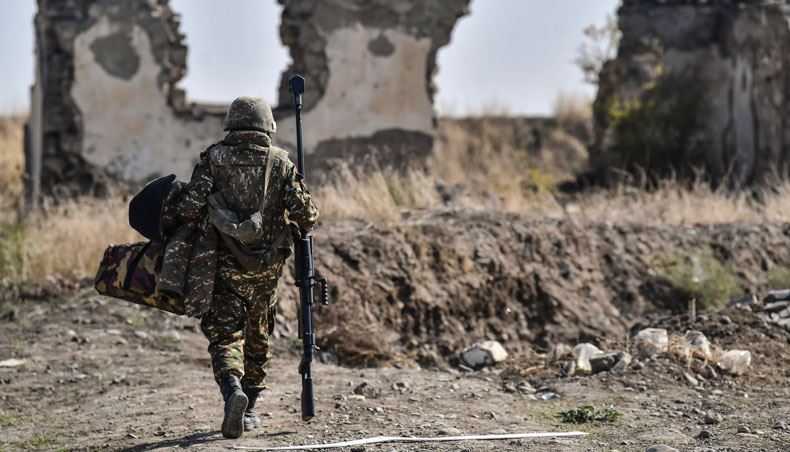 In this file photo taken on October 18, 2020 an Armenian soldier carries his machine gun at the front line as troops hold positions during the ongoing fighting between Armenia and Azerbaijan over the disputed region. — AFP photo