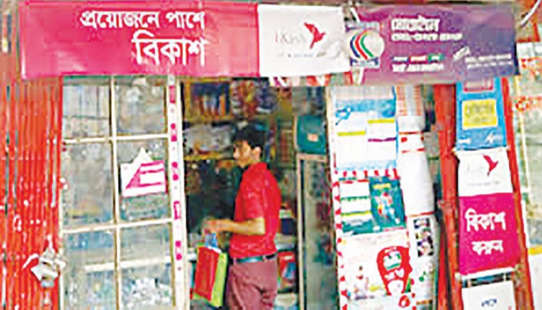 A file photo shows a man standing inside a shop that gives mobile financial service and mobile recharge service in Dhaka. — New Age photo