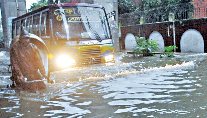 Vehicles ply a road that went under waist-high water after heavy rainfall in Gate Number 2 area in Chattogram on Friday. — Star Mail photo