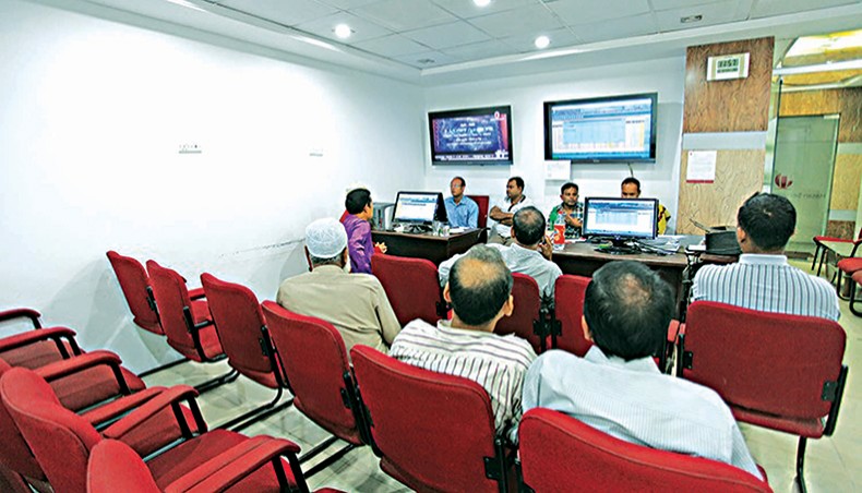 A file photo shows investors monitoring share price movements at a brokerage house in Dhaka. More than 50 per cent of the brokerage houses in the Dhaka Stock Exchange trade shares worth below Tk 1 crore daily that has led the houses to struggle with poor earnings for years. — New Age photo